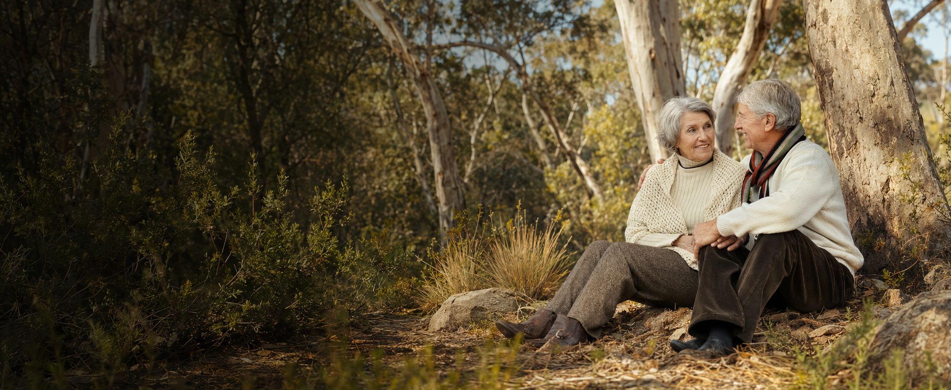 An older couple sitting together and talking outdoors